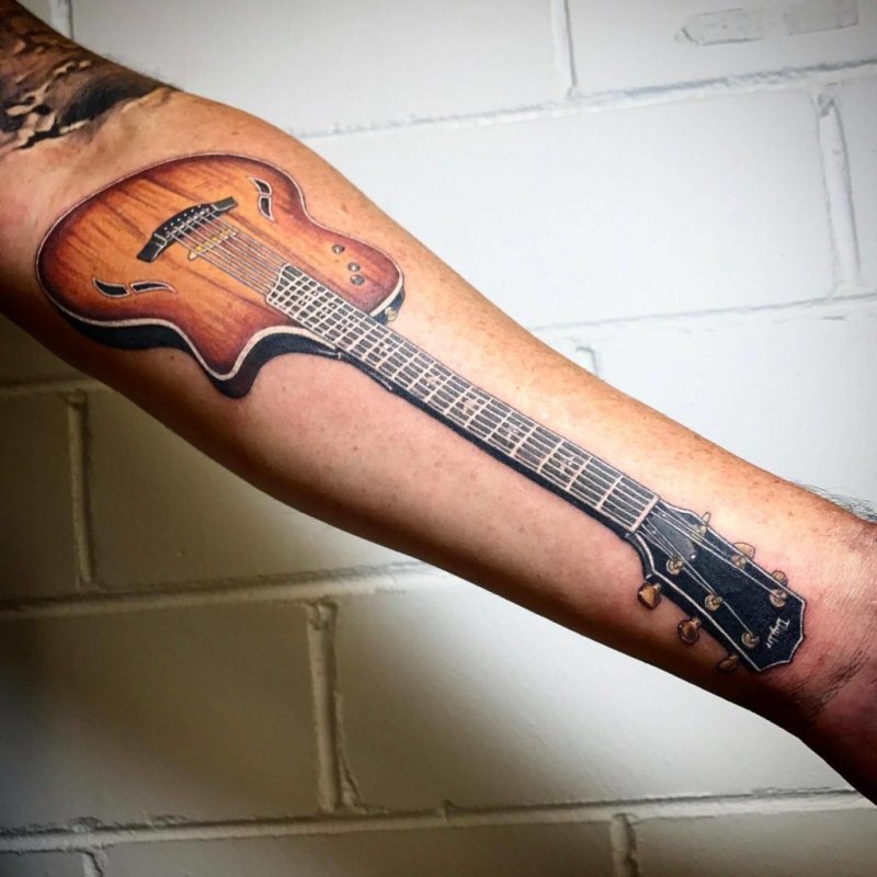 Guitar tattoo on the arm for men