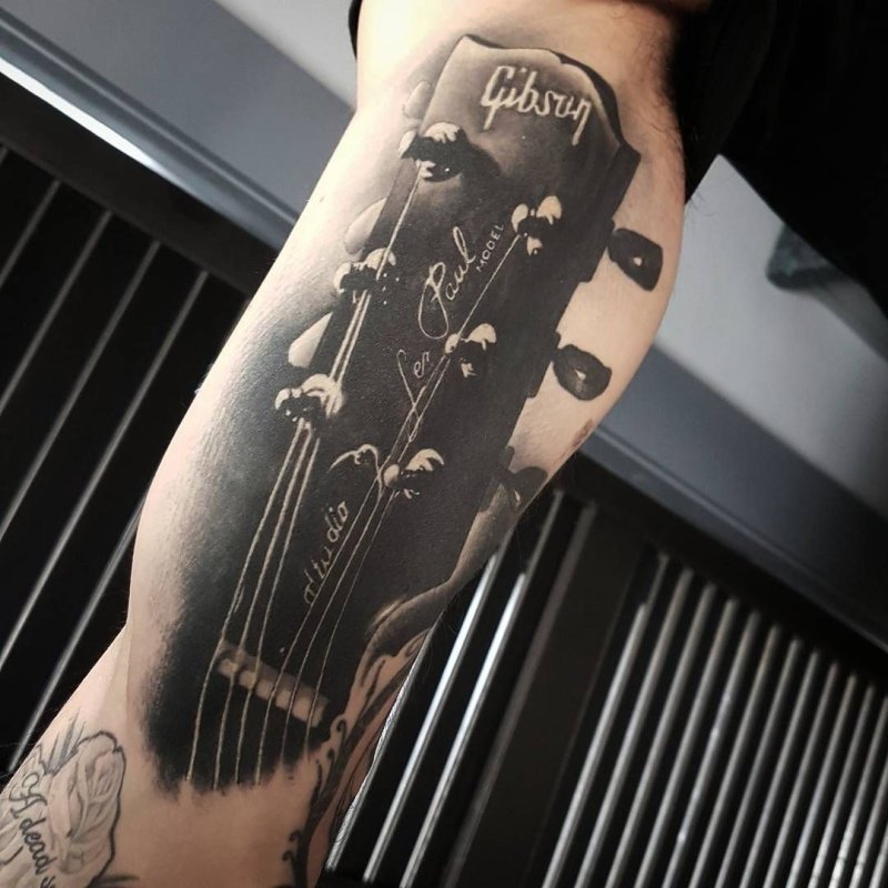 Guitar tattoo on the shoulder for men