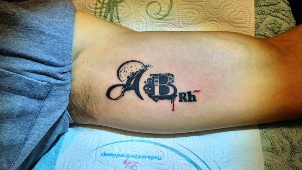 Blood type tattoo on biceps for men