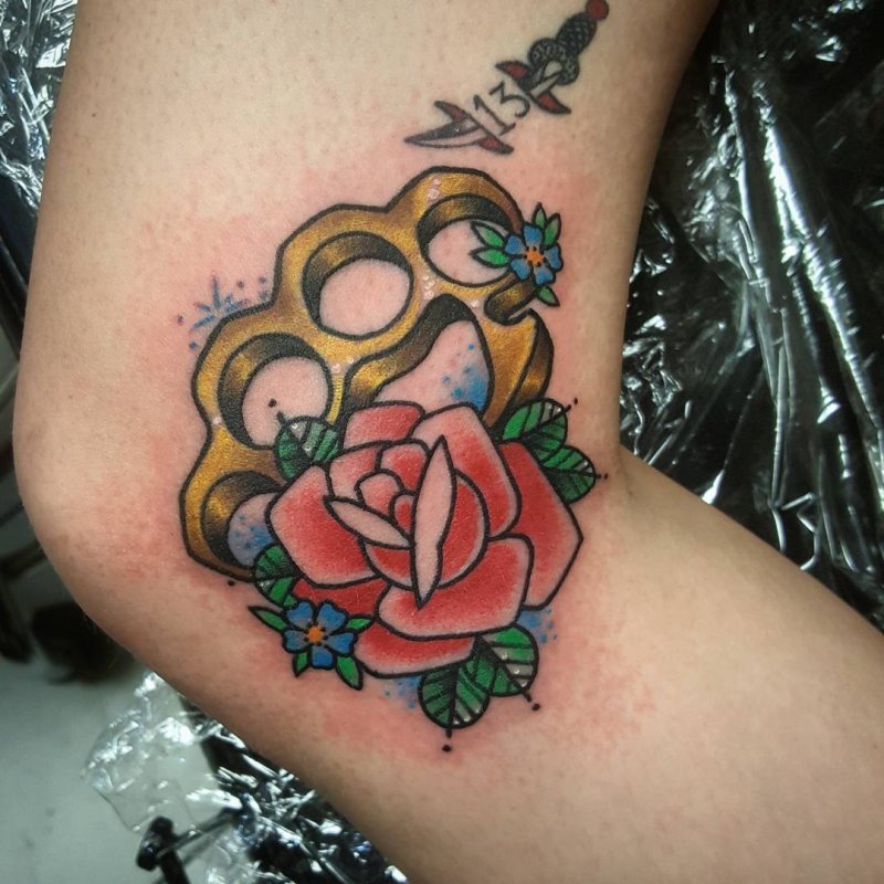 Colorful knuckle tattoo on knee for women