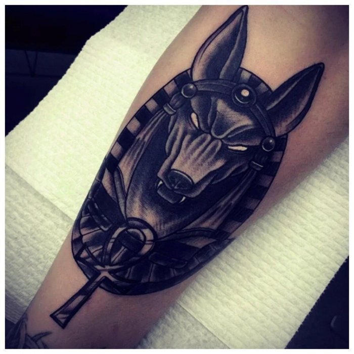 Anubis tattoo on the shin for women