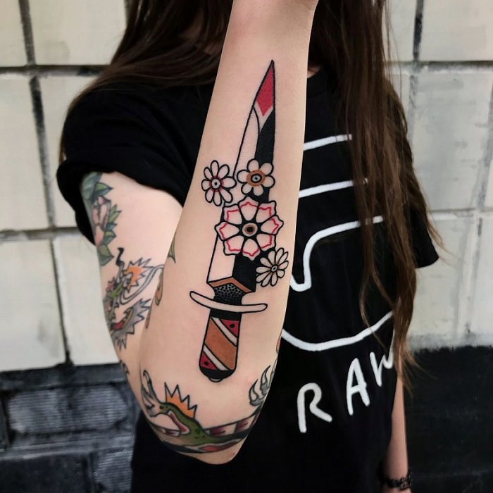 Old skool style dagger tattoo on the arm for women