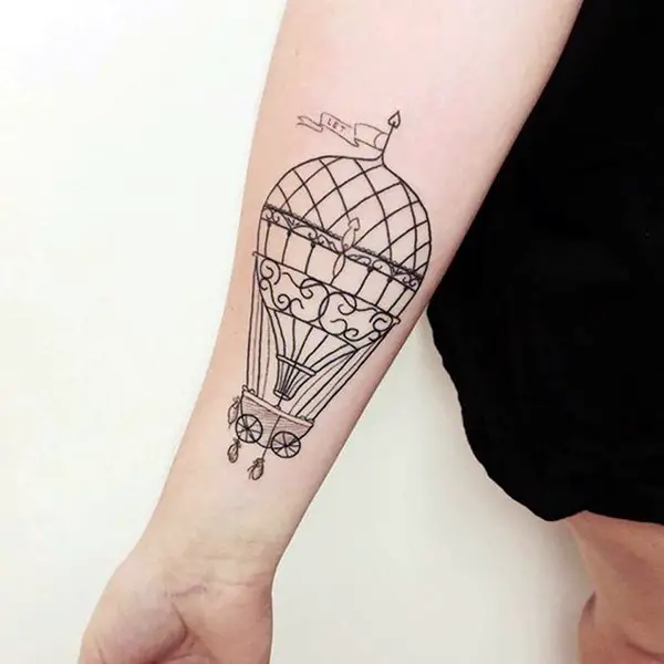 Large balloon tattoo on forearm for women