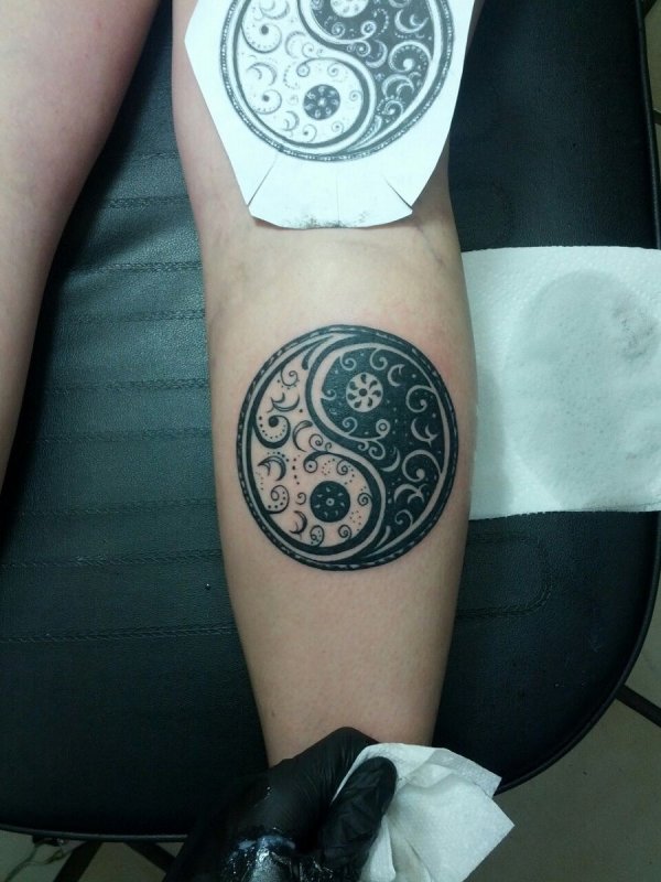 Yin-yang tattoo on the calf for men