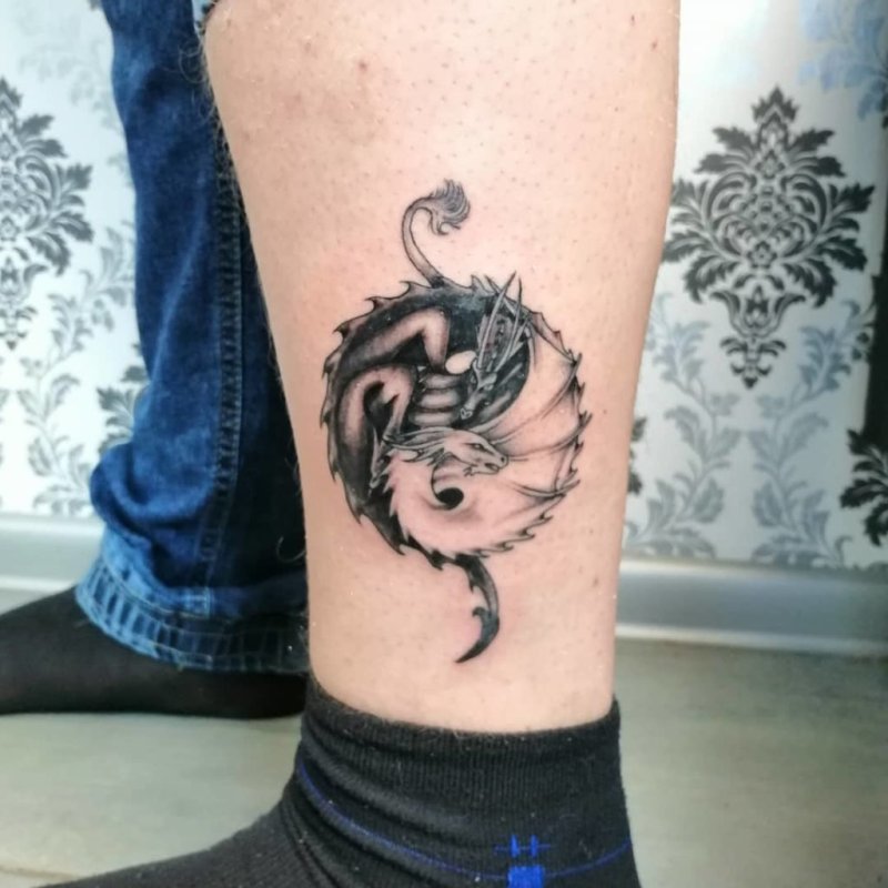 Yin-yang tattoo on the shin for men