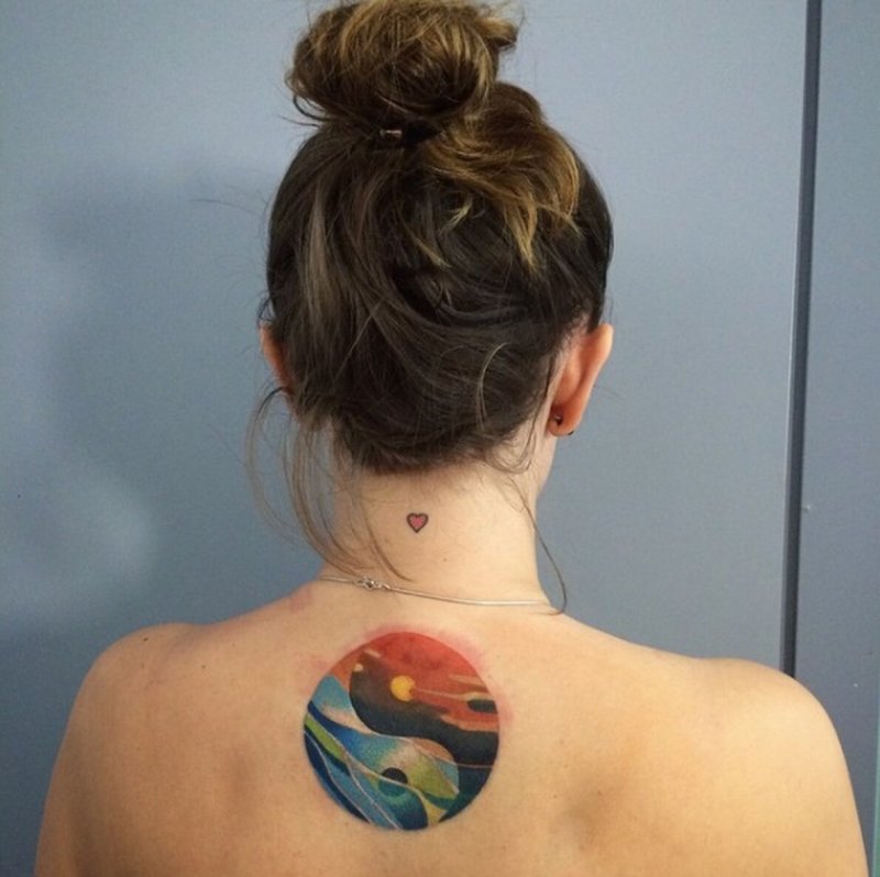 Yin-yang tattoo on back for women