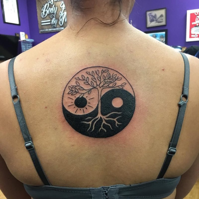 Yin-yang tattoo on back for women