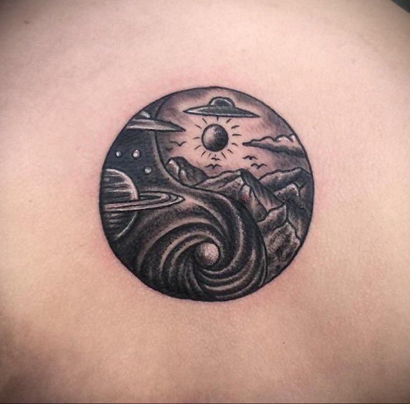 Yin-yang tattoo on back for women