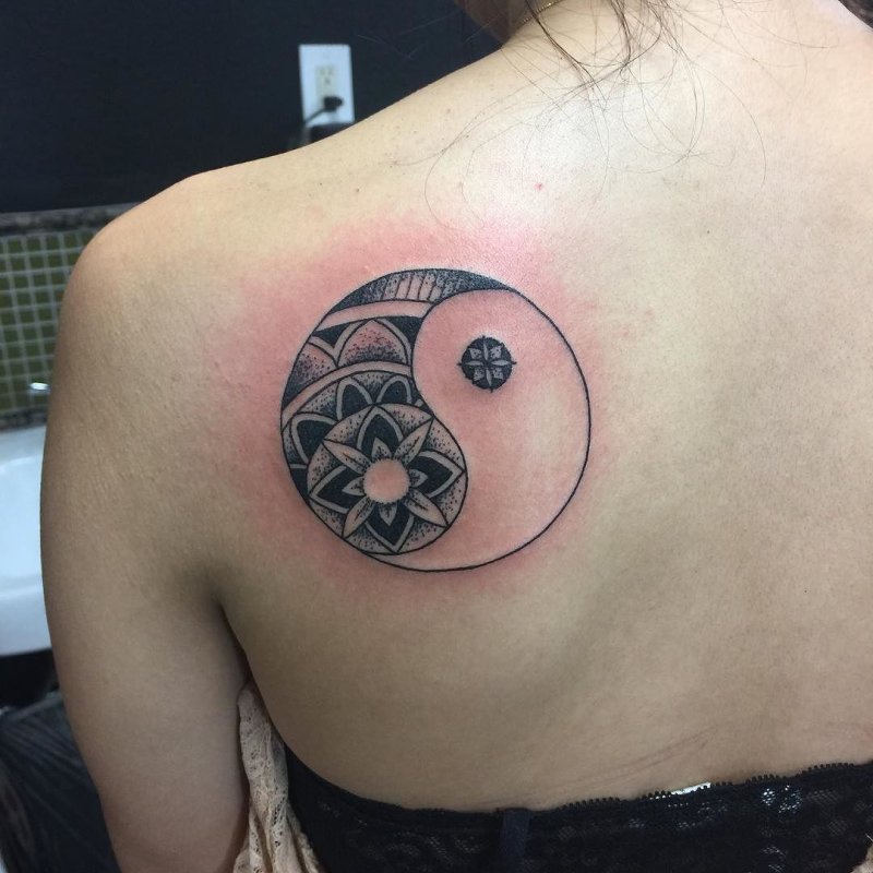 Yin-yang tattoo on the shoulder blade for women