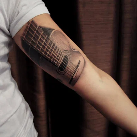 Guitar tattoo on the shoulder for men