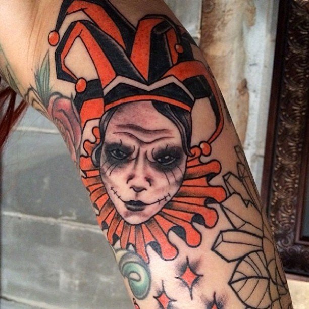 Harlequin tattoo on the arm for men