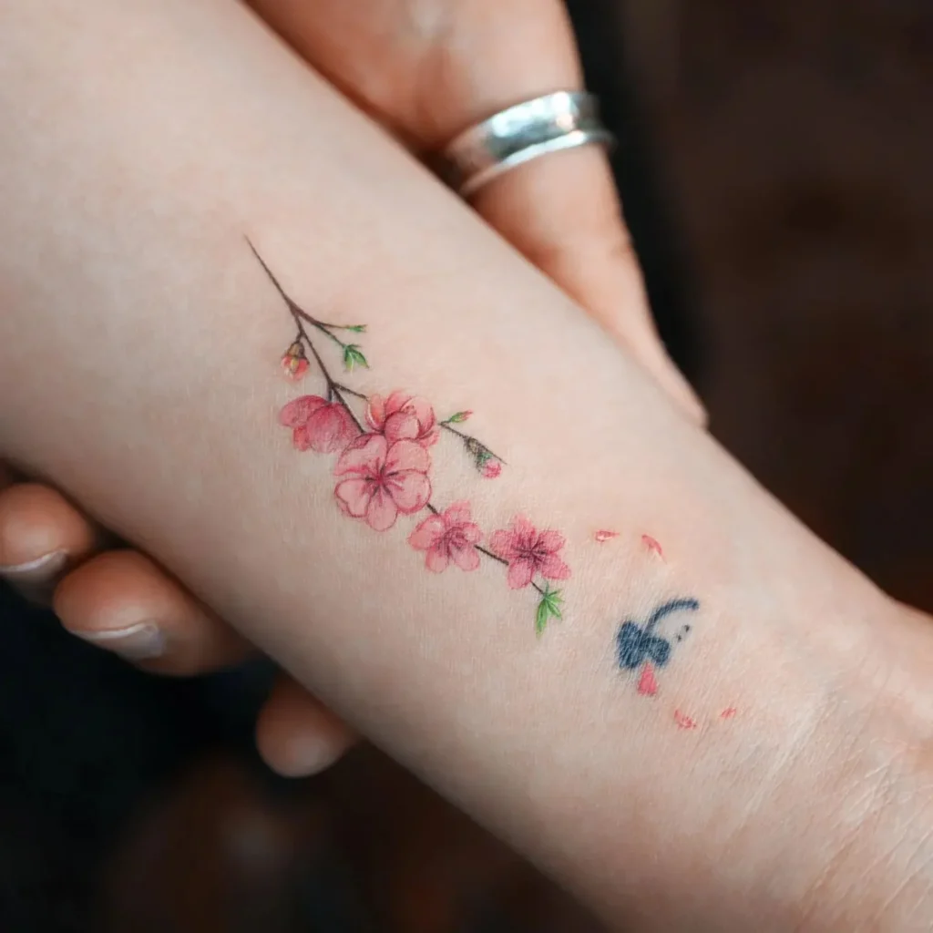 Sakura color tattoo on forearm for women