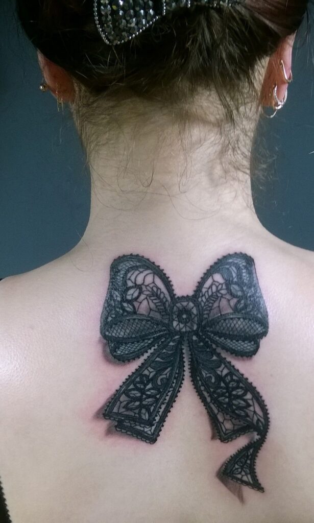 Large bow tattoo on the back for women