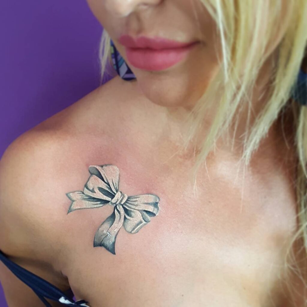 Bow tattoo on collarbone for women