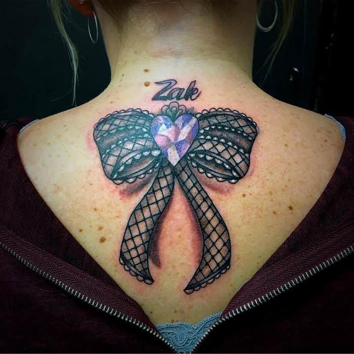 Bow tattoo on back for women