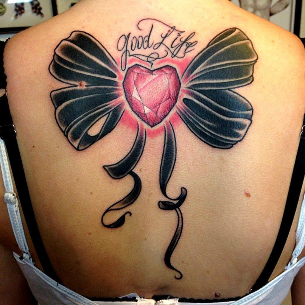 Bow tattoo on back for women