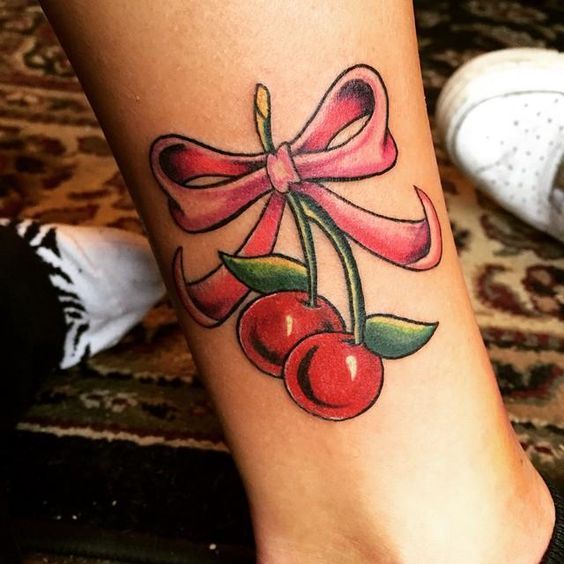 Bow and cherry tattoo on shin for women