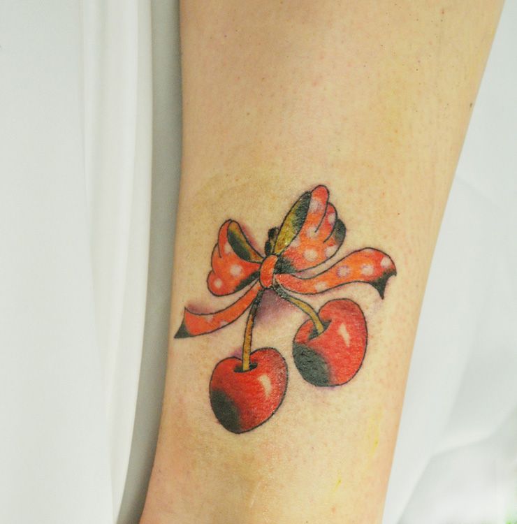 Bow and cherry tattoo on shin for women