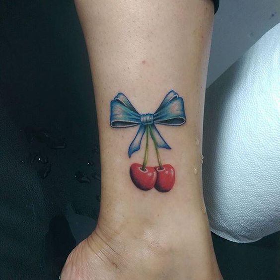 Bow and cherry tattoo on shin for women