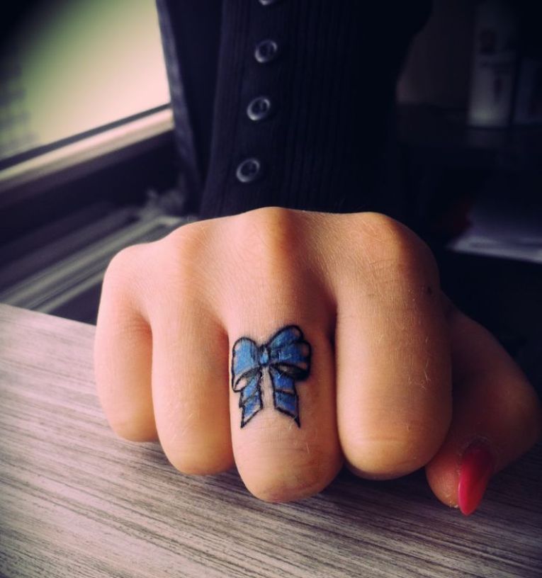 Bow tattoo on the finger for women