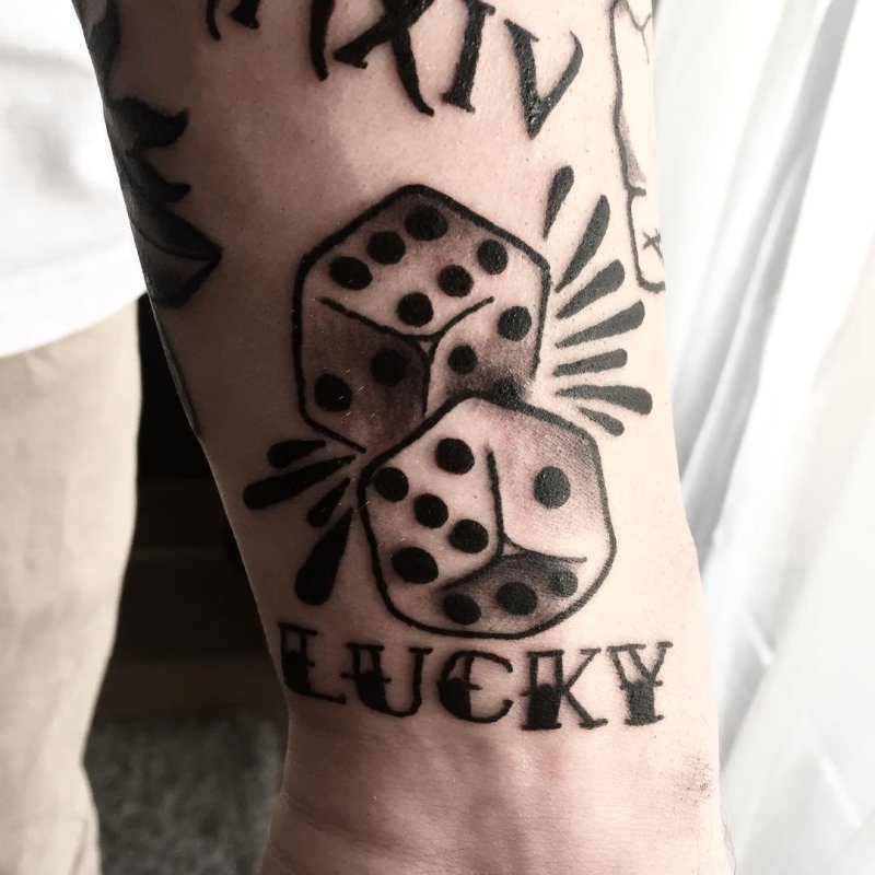 Dice tattoo with inscription on forearm for men