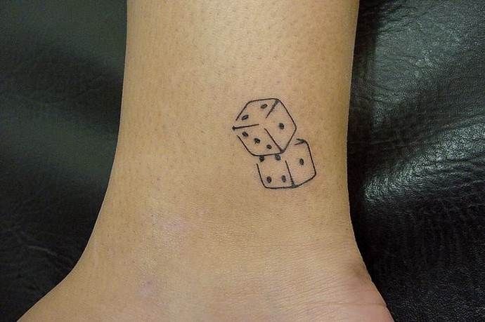 Dice tattoo on shin for women