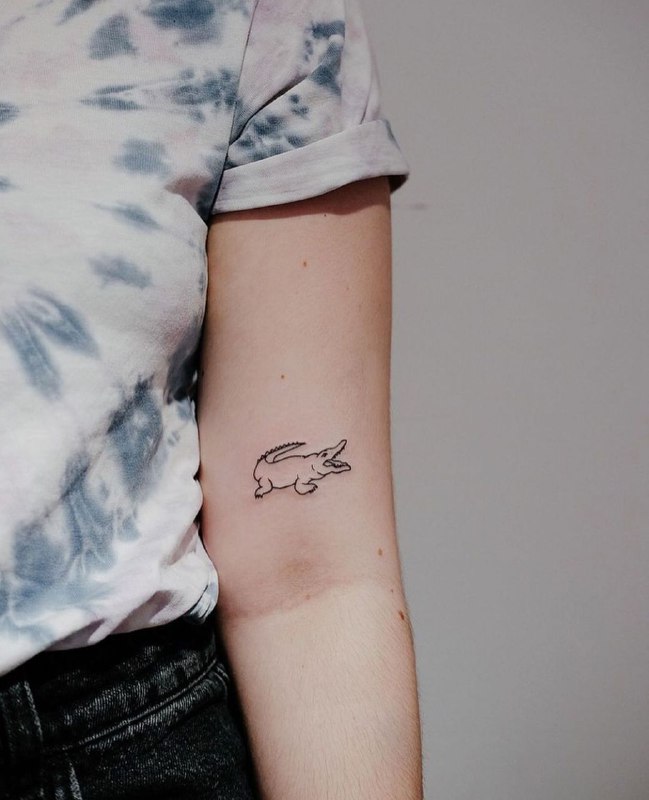 Minimalist crocodile tattoo on the shoulder for women