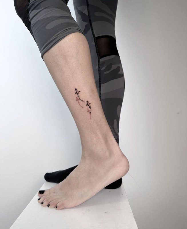 Minimalist style tattoo on the lower leg for women