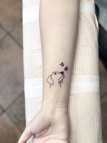 Minimalist dog tattoo on the forearm for women