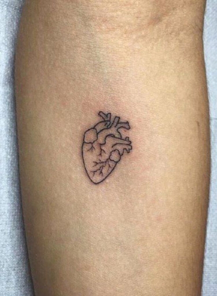 Minimalist heart tattoo on the forearm for women