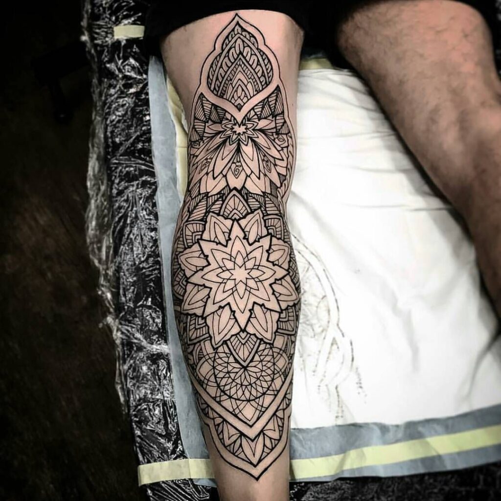 Ornamental style tattoo on the leg for men