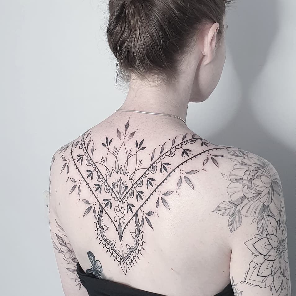 Ornamental style tattoo on the back for women