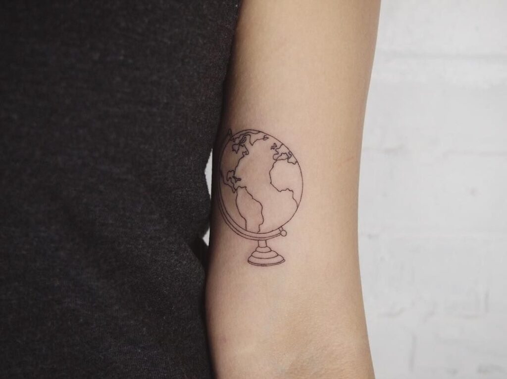 Globe tattoo on shoulder for women