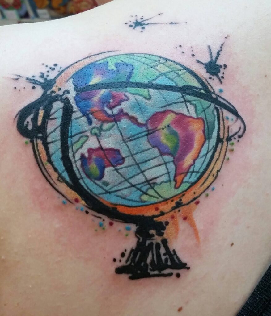 Colorful globe tattoo on shoulder blade for women