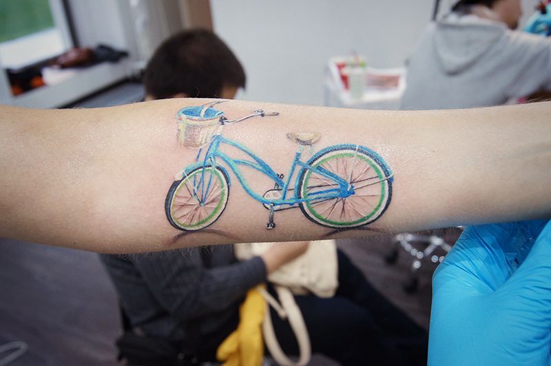 Colorful bicycle tattoo on arm for men