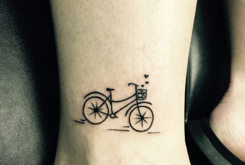 Bicycle tattoo on the shin for women