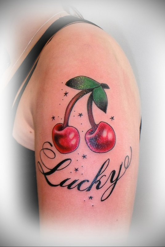 Cherry colored tattoo with writing on shoulder for women