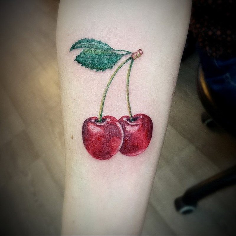 Cherry tattoo on forearm for women