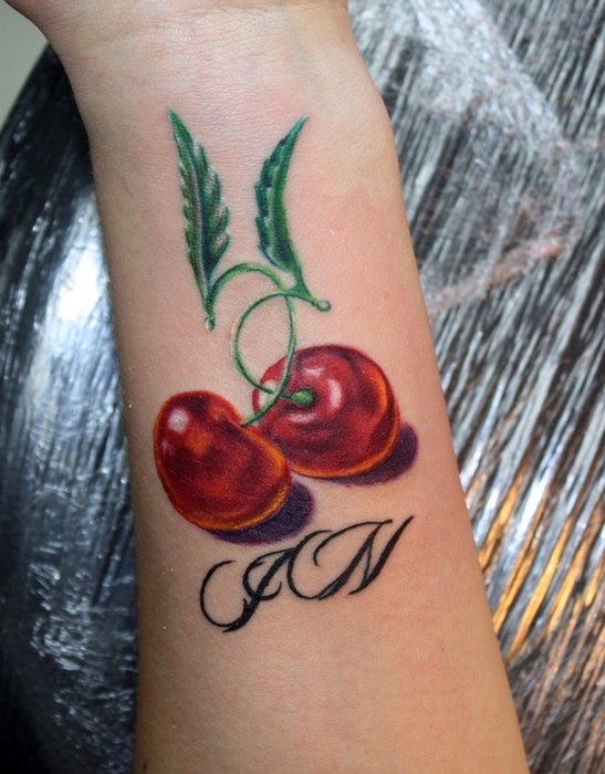 Cherry tattoo on the arm for women