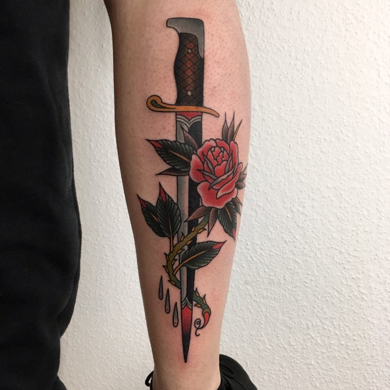 Dagger and flowers tattoo on the calf for men