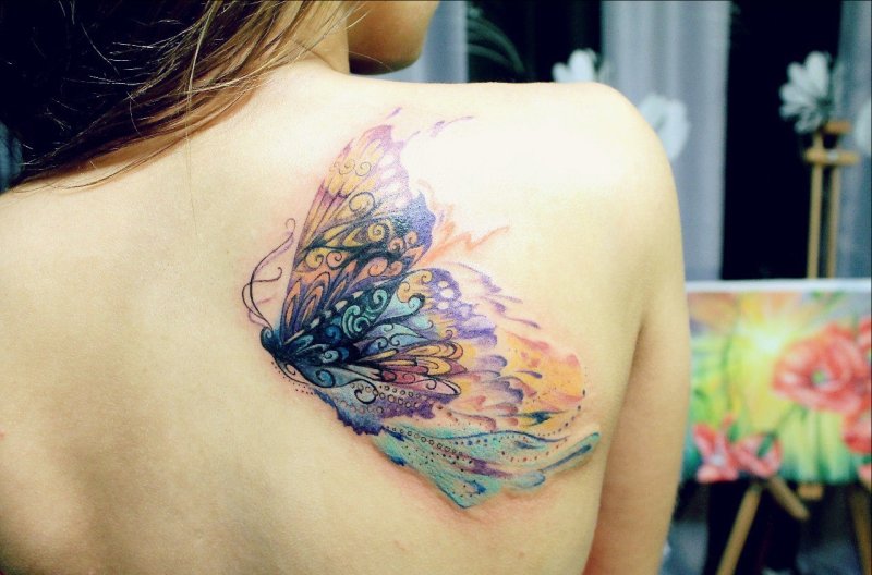 Watercolor style tattoo on the shoulder blade for women