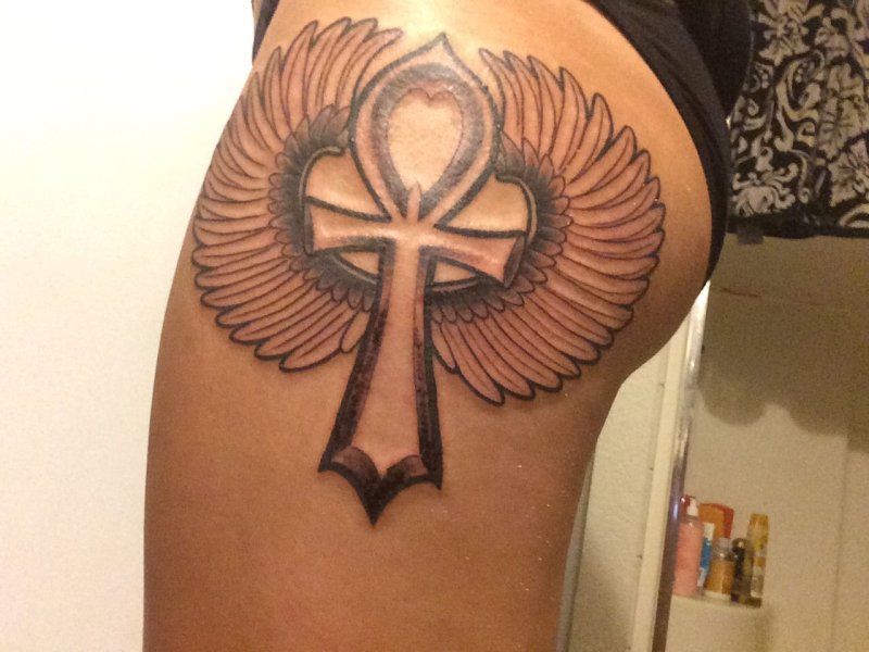 Large ankh tattoo on the thigh for women