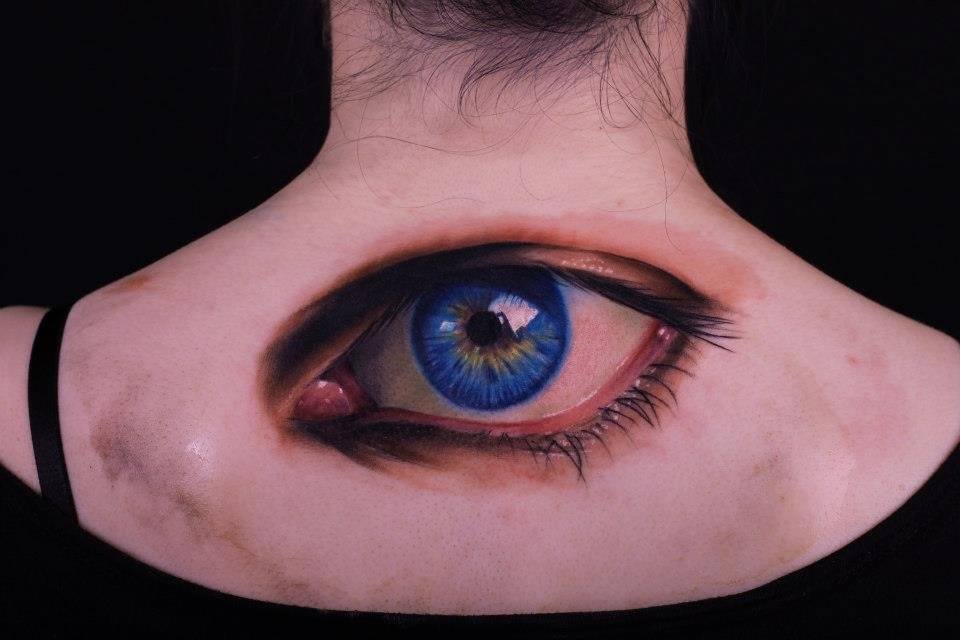 Colorful eye tattoo on back for women