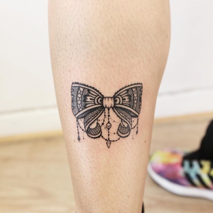 Bow tattoo on calf for women