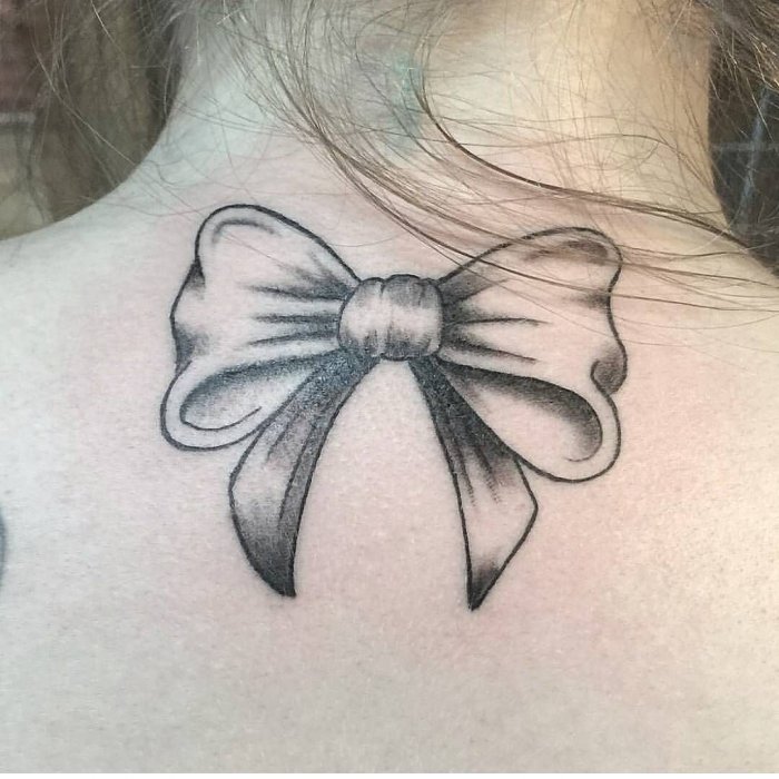 Bow tattoo on back for women