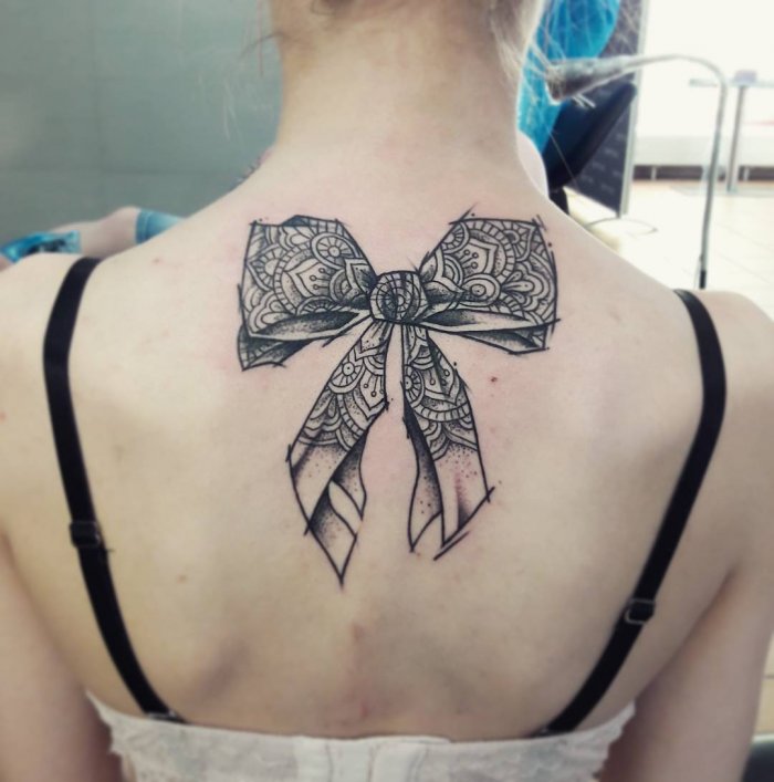 Bow tattoo on back for women