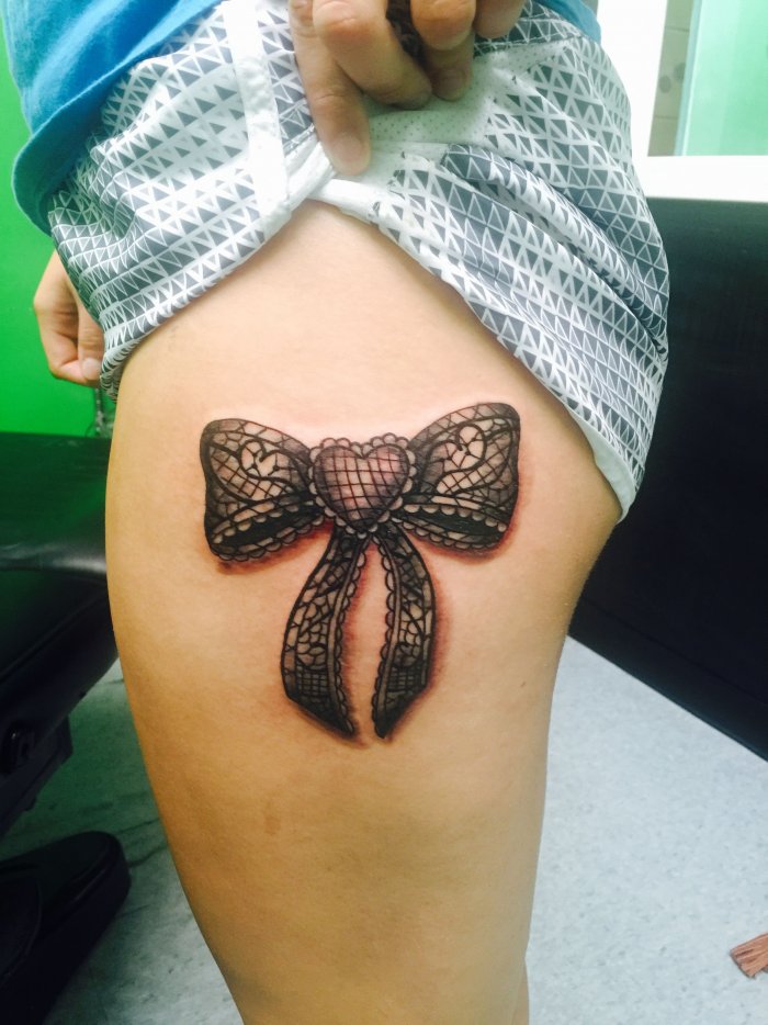 Bow tattoo on thigh for women