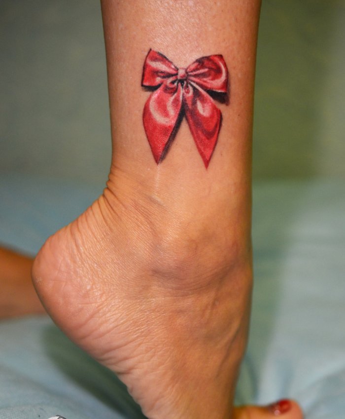 Bow tattoo on leg for women