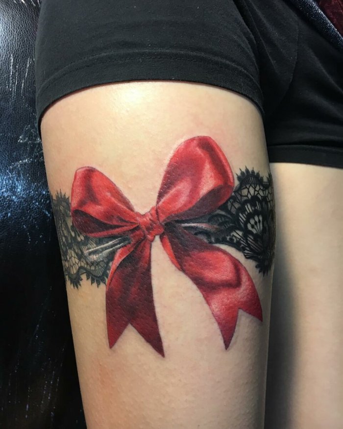 Bow tattoo on thigh for women