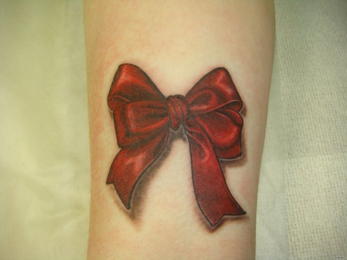 Colorful bow tattoo on arm for women